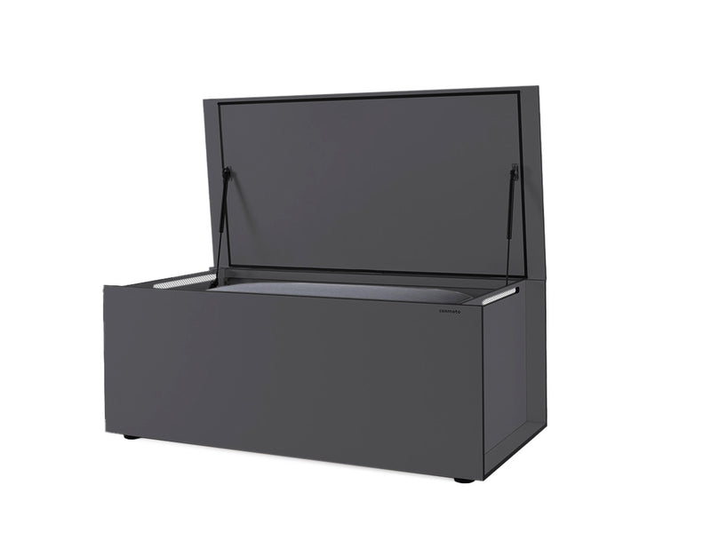 Graue Kissentruhe aus wetterbeständigem HPL-Material mit offenem Deckel. Die klare, rechteckige Form und minimalistisches Design zeichnen das Möbelstück aus. Gasdruckfedern halten den Deckel, integrierte Lüftungsschlitze und eine Gummidichtung am Rand sorgen für Belüftung und Wasserdichtigkeit. Die Truhe sitzt auf verstellbaren Füßen für Stabilität auf unebenem Boden.